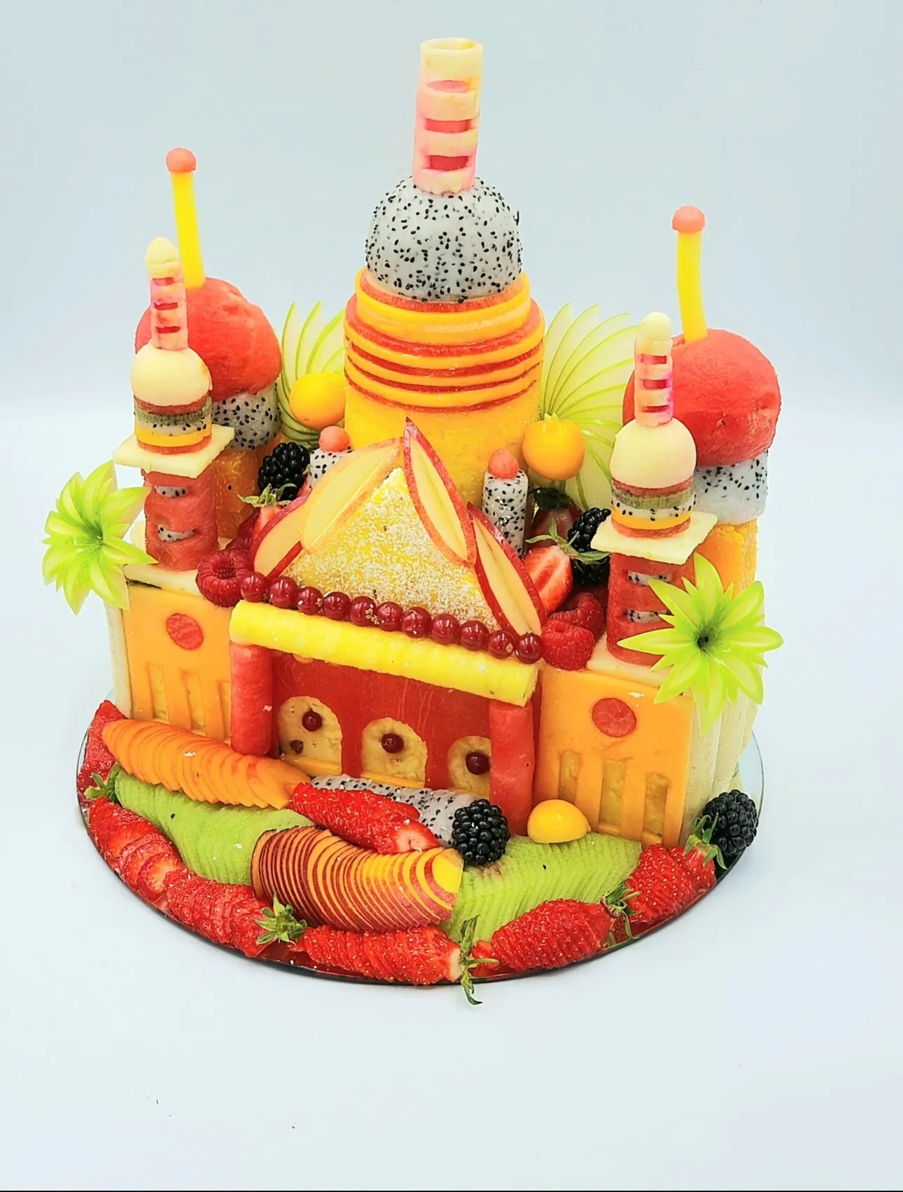 Création architecturale en fruits : tours, dômes de pastèque et de pitaya, façade d'ananas et de pastèque.